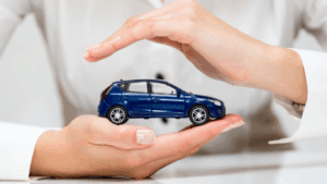 Pessoa segurando uma miniatura de carro nas mãos, para falar sobre a proteção veicular para carros financiados